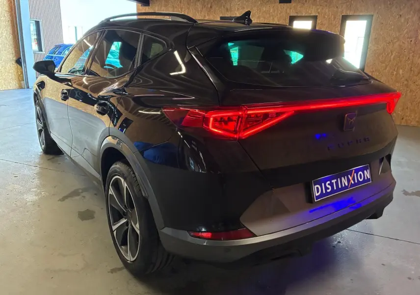 Vue 3/4 arrière droite du CUPRA Formentor noir avec feux arrière Tri-LED et double sortie d'échappement noire stylisée.