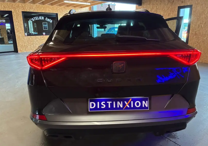 Vue arrière d'une CUPRA Formentor noire 2022 avec feux LED allumés et double sortie d'échappement noire stylisée.