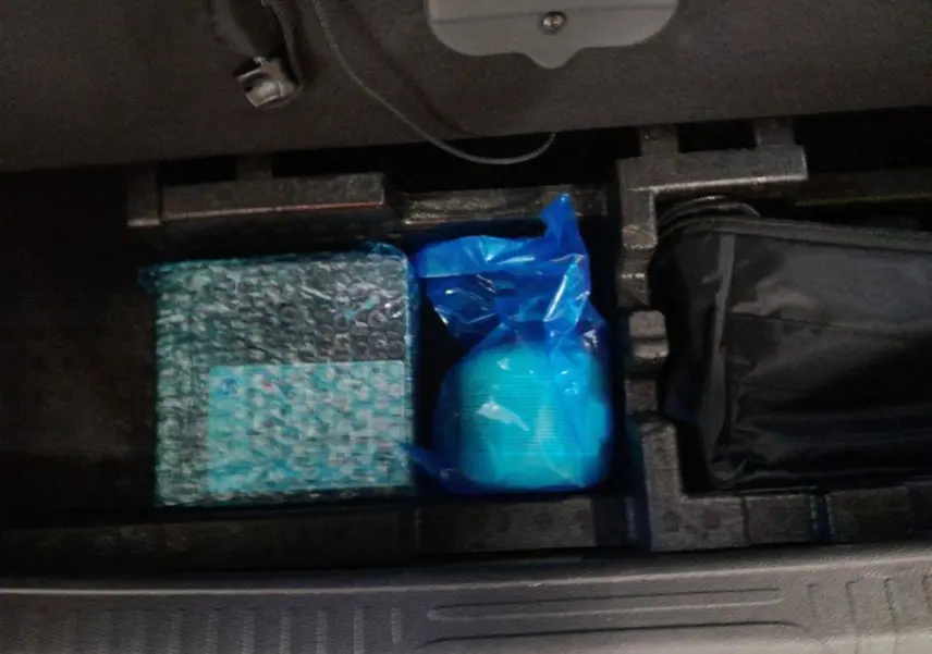 Rangement intérieur du coffre de la Peugeot 408 PHEV 180 e-EAT8 Allure noir, vue plongeante sur les accessoires rangés.