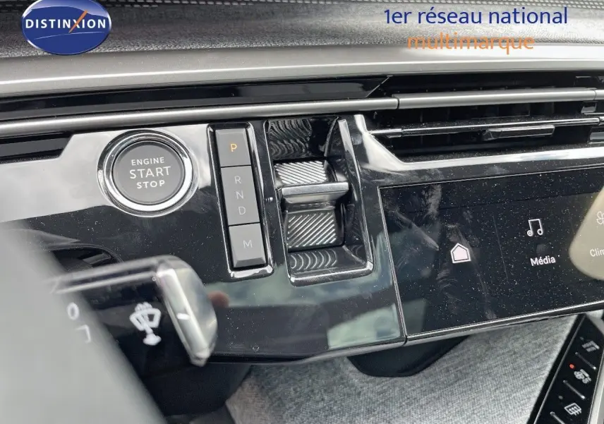 Détail du tableau de bord du Peugeot 5008 Hybrid 2025 avec bouton start/stop et commandes de boîte automatique.