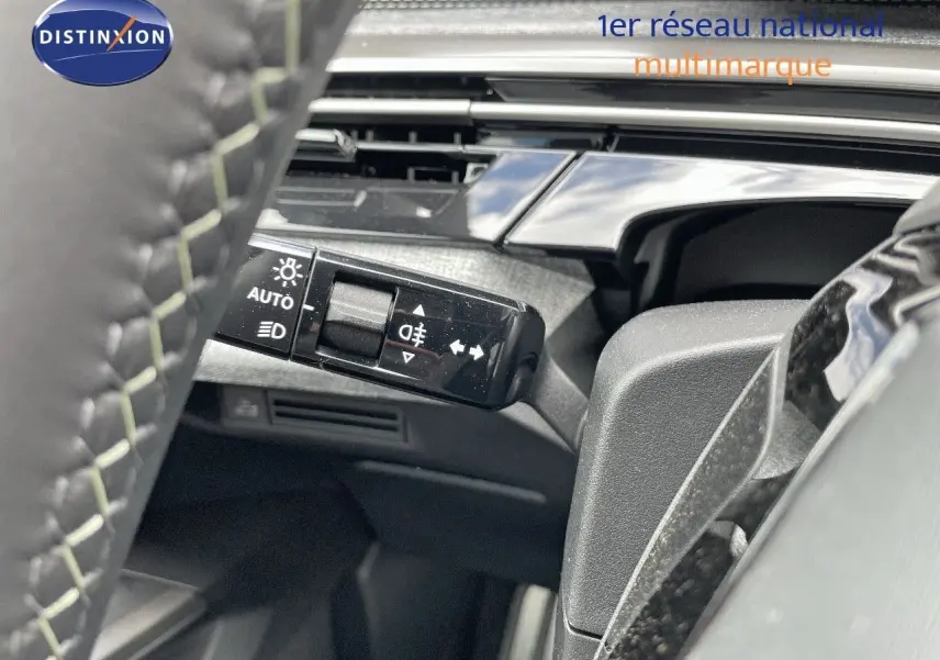 Gros plan sur la commande des feux et clignotants côté gauche du volant du Peugeot 5008 Hybrid 2025.