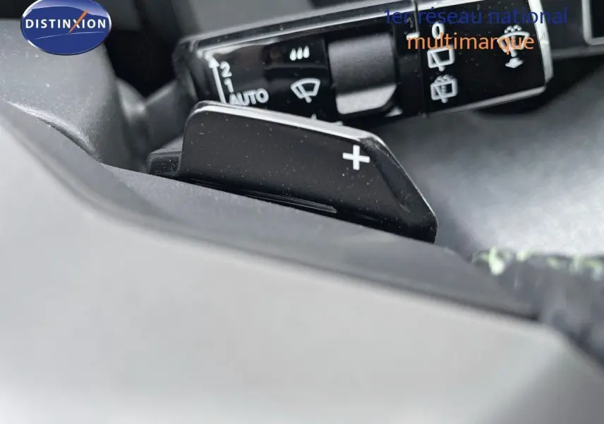 Gros plan sur le levier de vitesses automatique avec palettes au volant du Peugeot 5008 Hybrid blanc et toit noir.