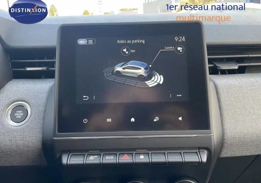 Écran tactile central affichant l'aide au parking dans l'habitacle d'une Renault Clio gris schiste métal, vue de face.