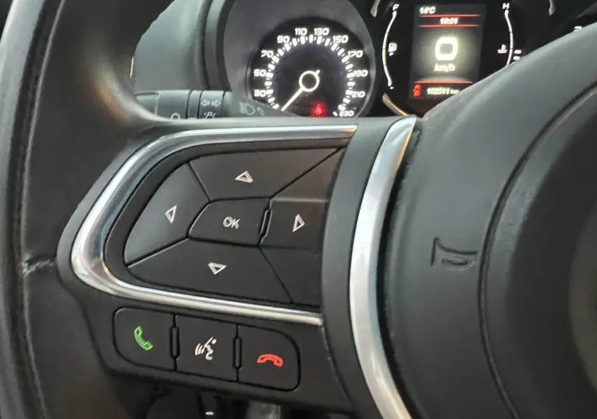 Gros plan sur les commandes au volant à gauche du tableau de bord du Fiat 500L 2017 avec affichage numérique du compteur.