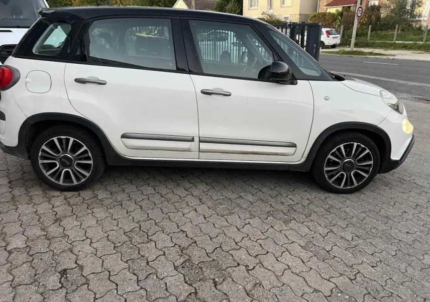 Profil côté gauche d'une FIAT 500L 2017 bi-color avec toit noir, roues alliage et poignées de porte grises.