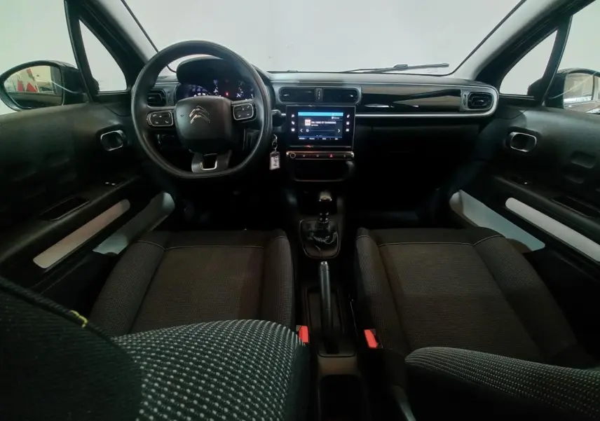 Intérieur noir de la Citroën C3 2024, vue de face sur le tableau de bord avec écran tactile et volant multifonctions.