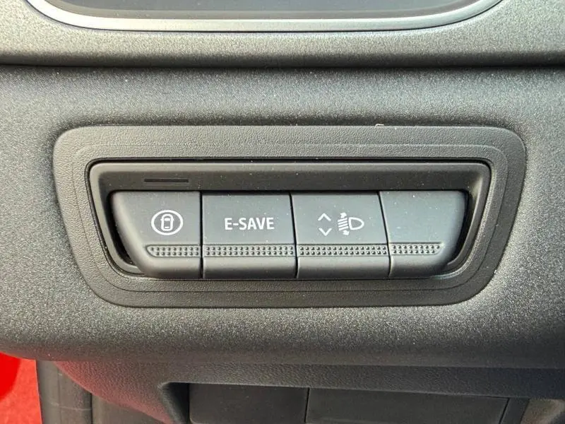 Gros plan sur les boutons de commande E-SAVE et réglage des phares dans un Renault Captur Rouge Flamme 2025.