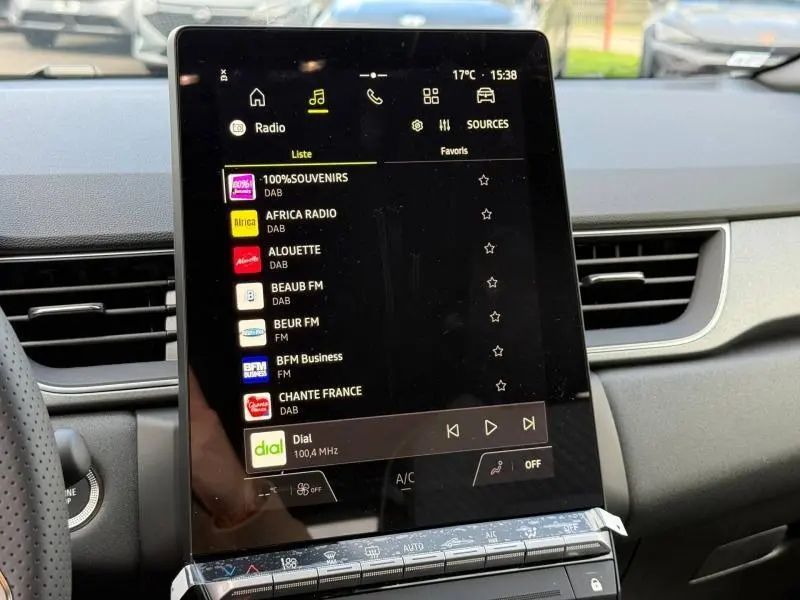 Écran tactile central du Renault Captur 2025 affichant les stations radio, intérieur avec tableau de bord gris.
