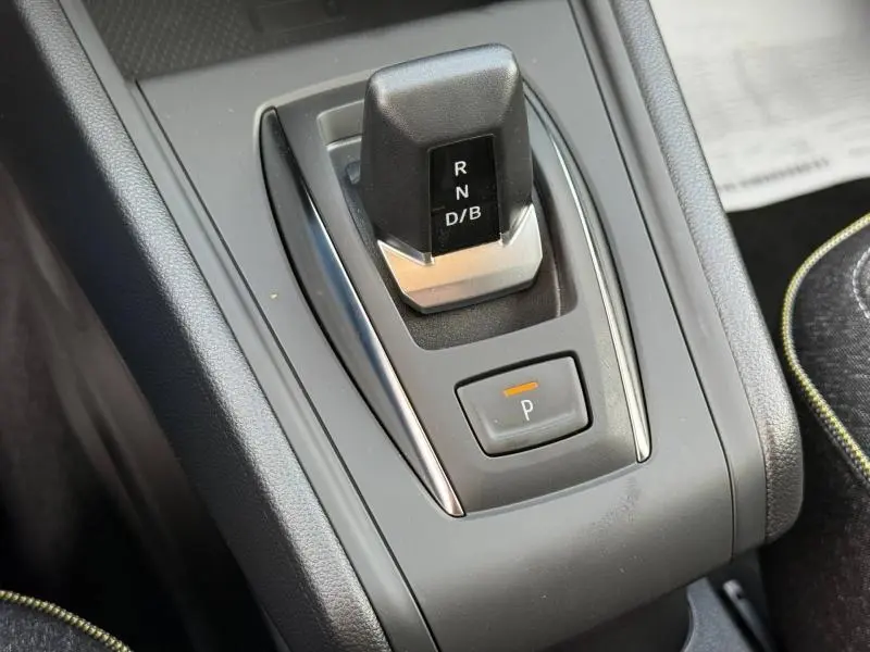 Gros plan sur la commande de boîte automatique du Renault Captur 2025, avec levier noir et bouton de parking éclairé.