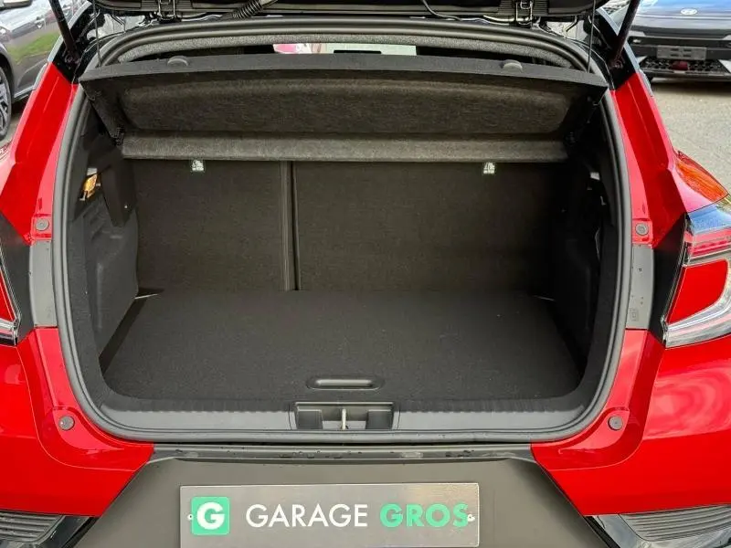 Coffre ouvert vu de l'arrière d'un Renault Captur 2025 Rouge Flamme, montrant l'espace de chargement vide.
