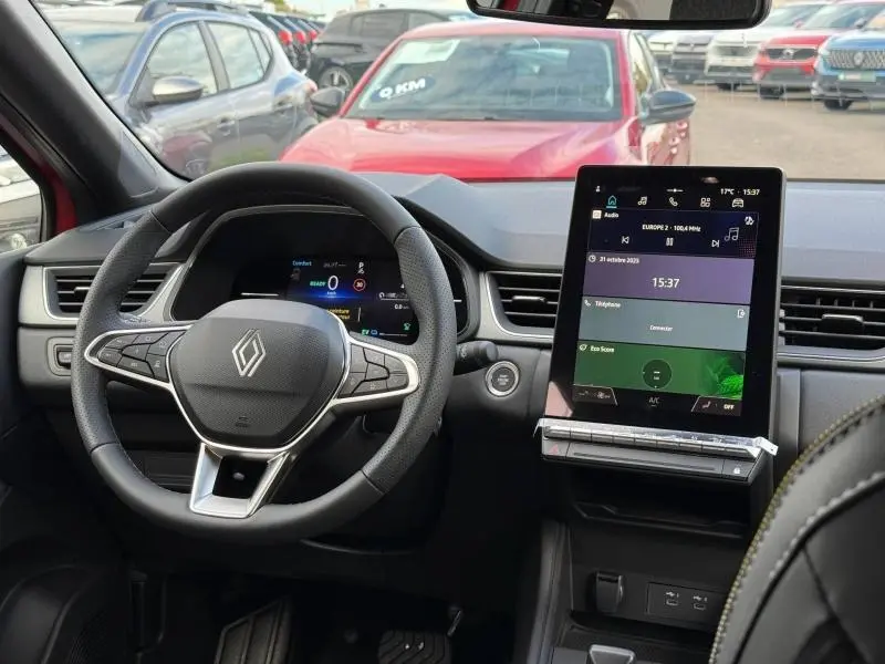 Vue intérieure du tableau de bord et volant du Renault Captur 2025 hybride, avec écran tactile vertical et détails modernes.