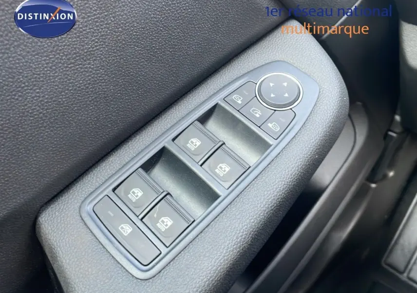 Gros plan sur les commandes des vitres électriques côté gauche d'une Renault Clio noire étoile métal, version 2025.