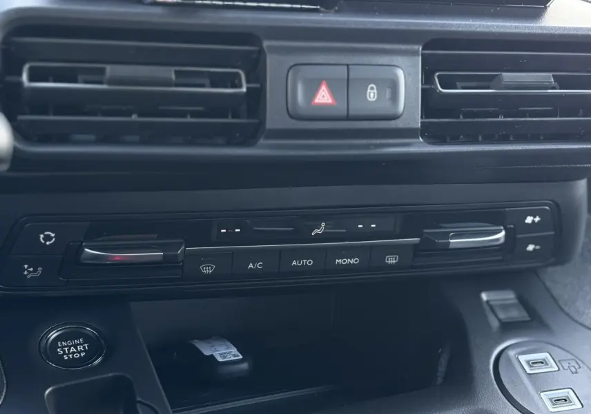 Vue rapprochée de la console centrale noire du Citroën Berlingo Multispace 2025 avec commandes climatisation et bouton start-stop.