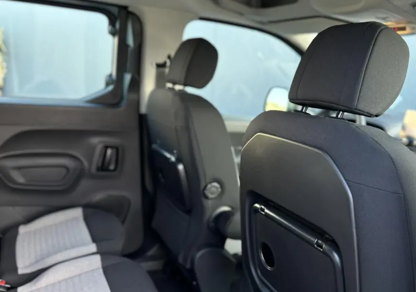 Intérieur du Citroën Berlingo Multispace bleu, vue sur les sièges arrière avec tablettes aviation rabattables.