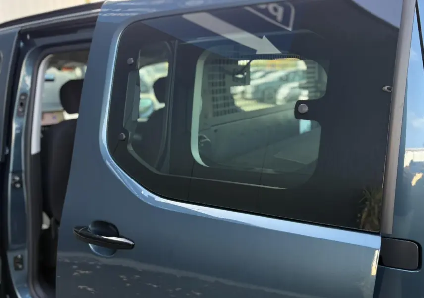 Porte latérale coulissante droite bleue du Citroën Berlingo Multispace 2025, vue rapprochée avec intérieur partiellement visible.