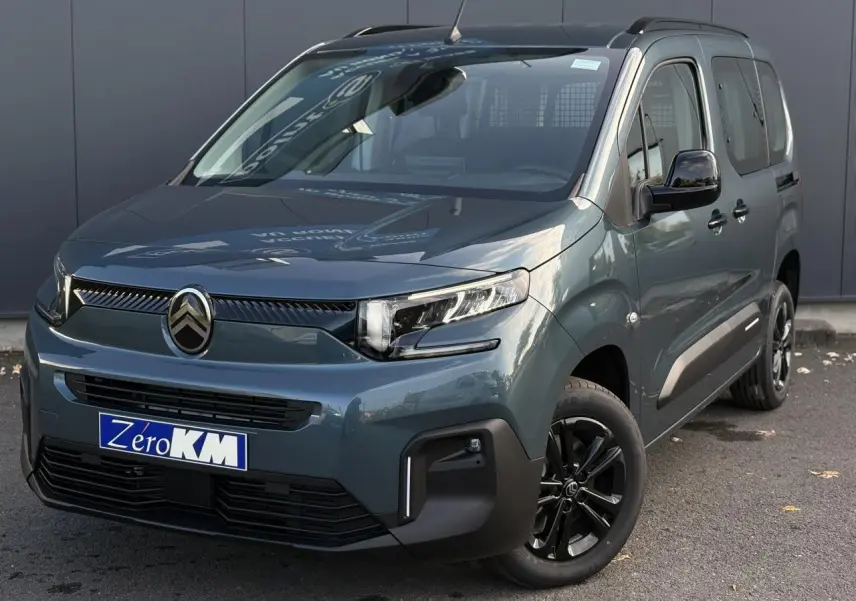 Vue 3/4 avant droit du Citroën Berlingo Multispace bleu métallisé avec jantes alliage noires et barres de toit.