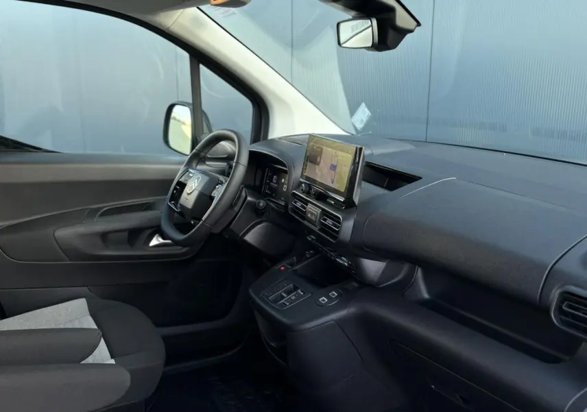 Vue intérieure côté conducteur du Citroën Berlingo Multispace 2025, tableau de bord noir avec écran tactile et volant multifonctions.