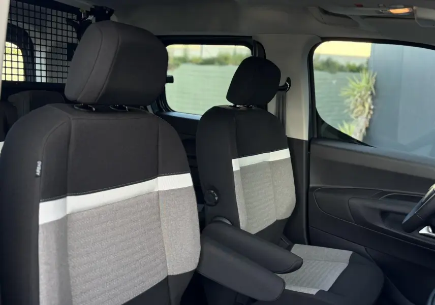 Vue intérieure côté droit du Citroën Berlingo Multispace 2025, sièges avant gris et noirs avec accoudoirs.