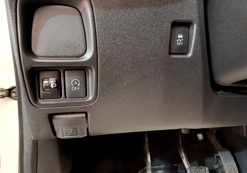 Détail intérieur montrant les commandes de réglage des phares, désactivation start-stop et antipatinage sur Citroën C1 blanche.