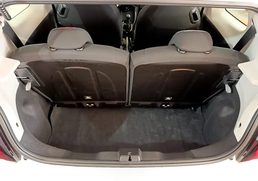 Vue du coffre arrière ouvert de la Citroën C1 blanche, montrant la banquette arrière 2 places rabattue 50/50.