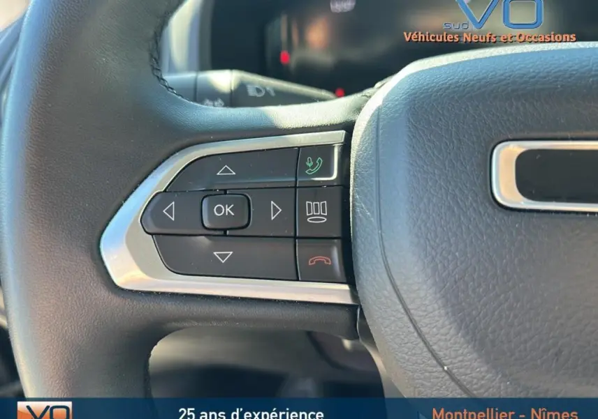 Gros plan sur les commandes gauche du volant noir du Jeep Renegade 2024, avec boutons de navigation et appel téléphonique.