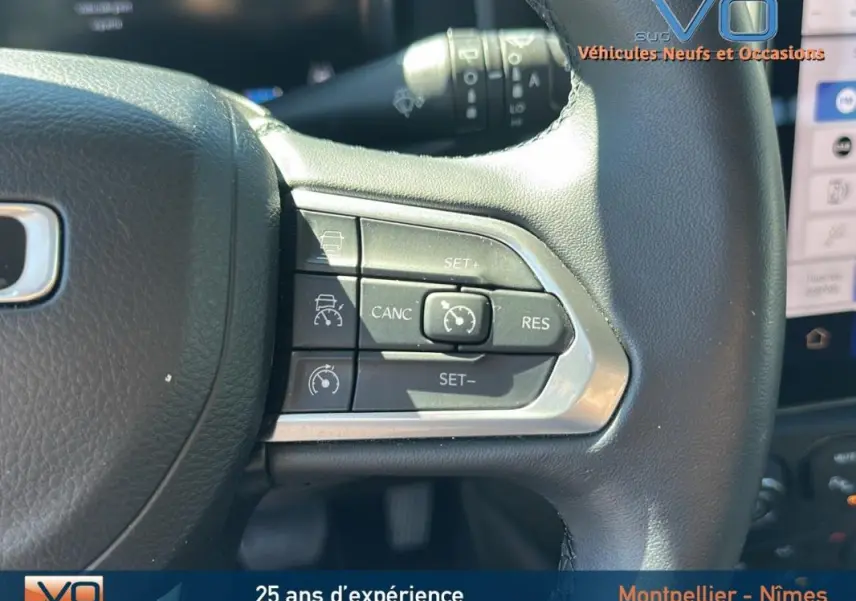 Gros plan sur le volant noir du Jeep Renegade 2024 montrant les commandes du régulateur de vitesse et de l’aide à la conduite.
