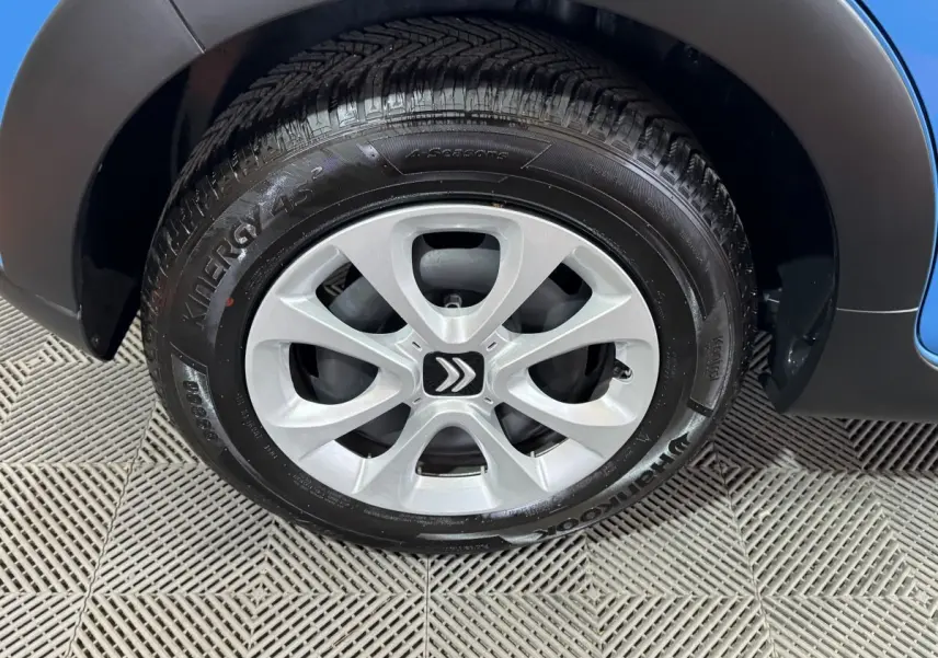 Gros plan sur la roue avant droite d'une Citroën C3 bleu, avec jante argentée et logo Citroën central.