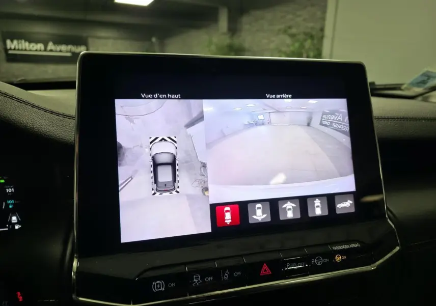 Écran central affichant la caméra 360° et vue arrière du Jeep Compass blanc en stationnement intérieur.