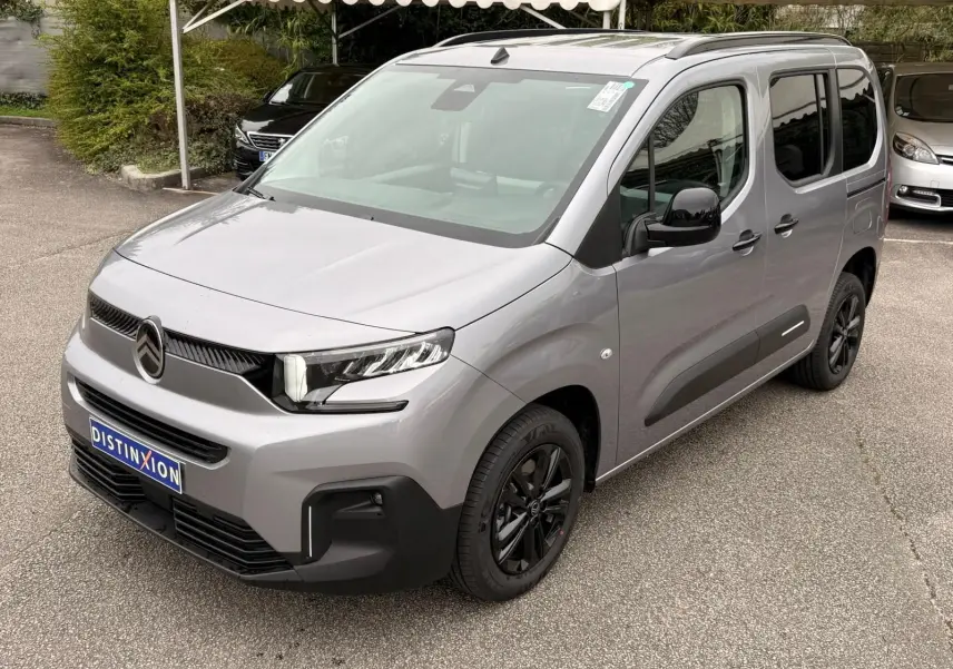 Citroën Berlingo gris Artense en 3/4 avant droit, avec jantes noires et détails noirs contrastants.