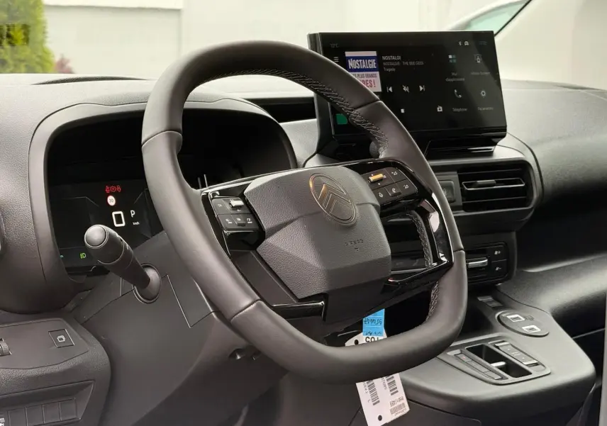 Vue rapprochée du volant et du tableau de bord numérique du Citroën Berlingo 2025, finition gris Artense.