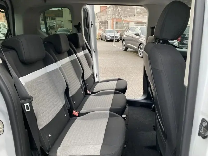 Vue intérieure côté droit des sièges arrière gris clair et noir du Citroën Berlingo Taille M 2025 avec porte coulissante ouverte.