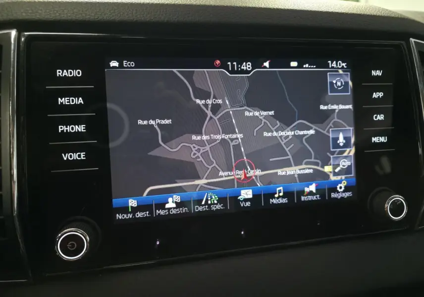 Écran tactile multimédia du tableau de bord du Skoda Karoq rouge, affichant la navigation GPS en mode carte.