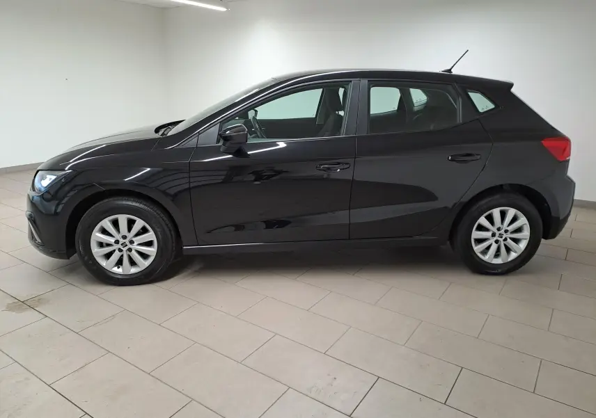 SEAT IBIZA 1.0 TSI 95 STYLE 2024 en noir minuit, vue de profil côté gauche dans un intérieur lumineux.