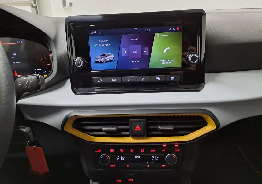 Vue intérieure centrée sur la console centrale de la SEAT IBIZA 2024 avec écran tactile et cadre d’aération jaune.
