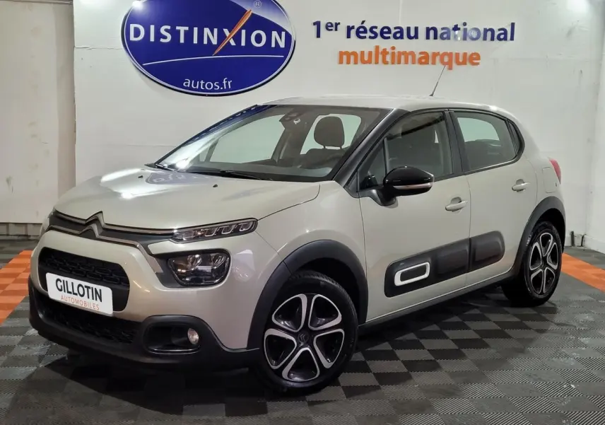 Citroën C3 beige vue 3/4 avant droit, avec protections latérales noires et jantes originales en alliage.