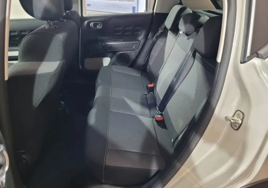 Vue intérieure côté droit sur la banquette arrière noire de la Citroën C3 beige PureTech 83 Feel Pack 2022.