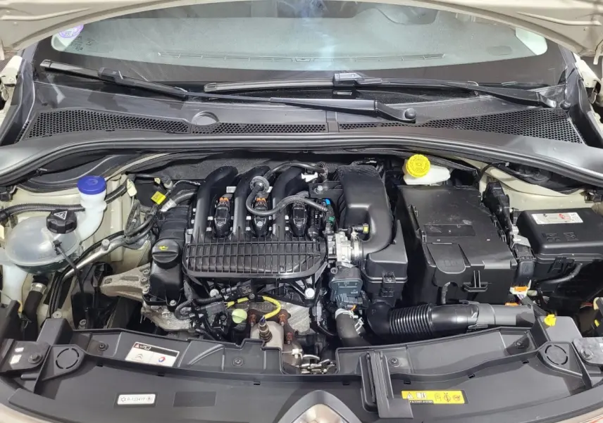 Vue rapprochée du moteur essence d'une Citroën C3 beige 2022, montrant les composants sous le capot ouvert.