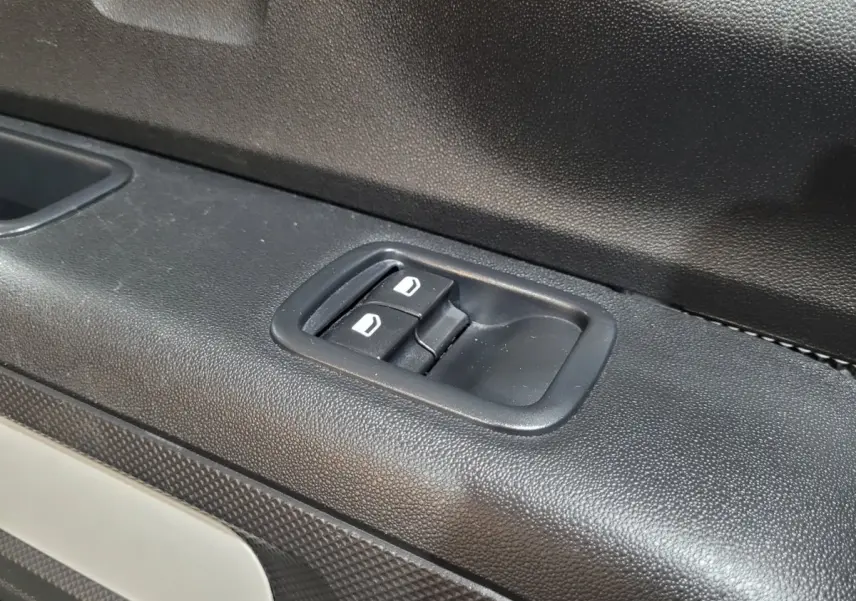 Gros plan sur les commandes de lève-vitres côté gauche d'une Citroën C3 beige, finition Feel Pack 2022.