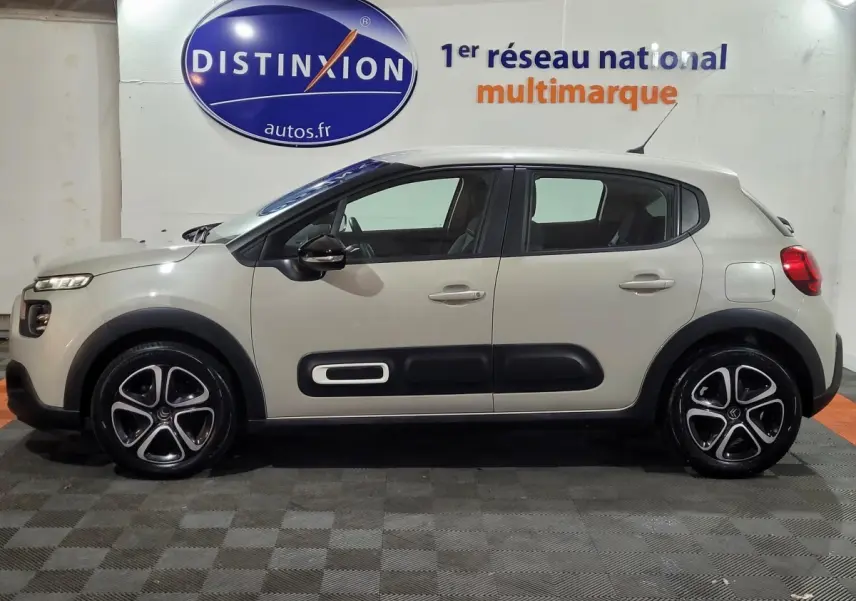 Vue de profil côté gauche d'une Citroën C3 beige 2022 avec protections latérales noires et jantes alliage distinctives.