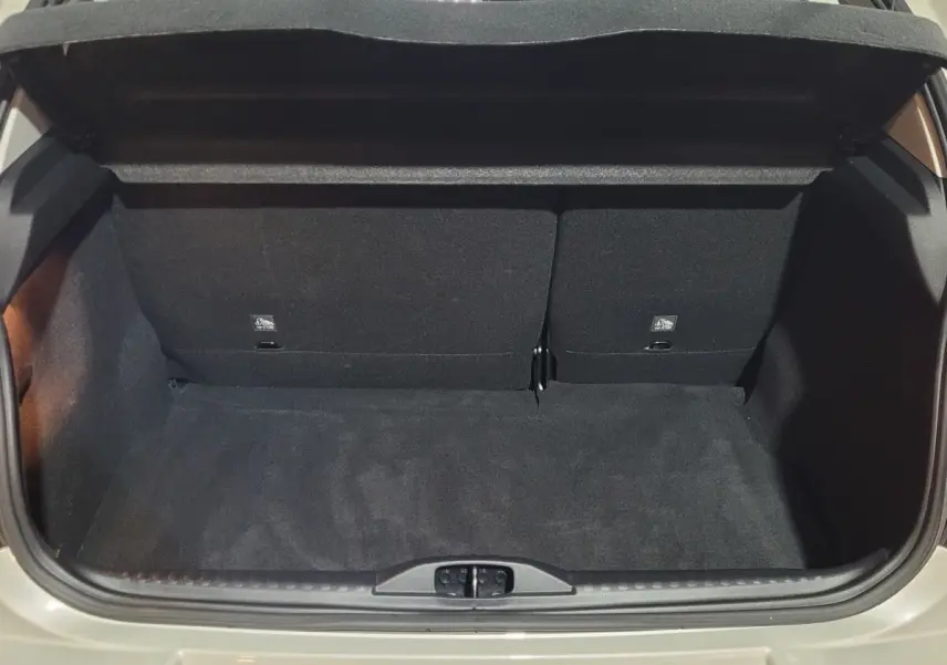 Coffre ouvert vu de l'arrière d'une Citroën C3 beige 2022, montrant l'espace de chargement avec banquette rabattue partiellement.