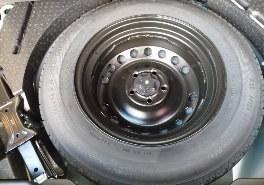 Gros plan sur la roue de secours noire dans le coffre d’un Renault Kadjar gris Titanium 2021.