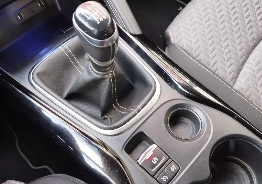 Gros plan sur la console centrale du Renault Kadjar gris titanium, mettant en valeur le levier de vitesses manuel et les commandes de frein à main électrique.