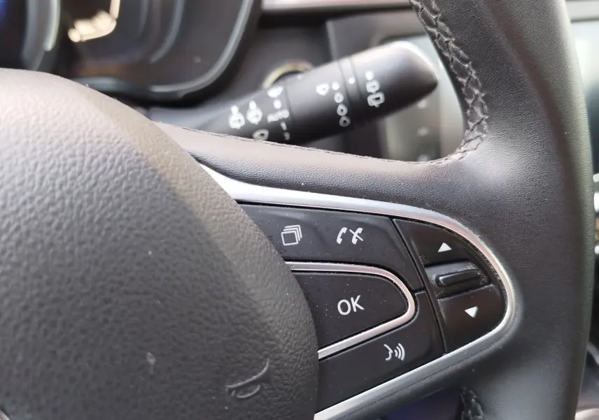 Gros plan sur les commandes au volant en cuir noir du Renault Kadjar 1.3 TCe 140ch gris Titanium, côté gauche.