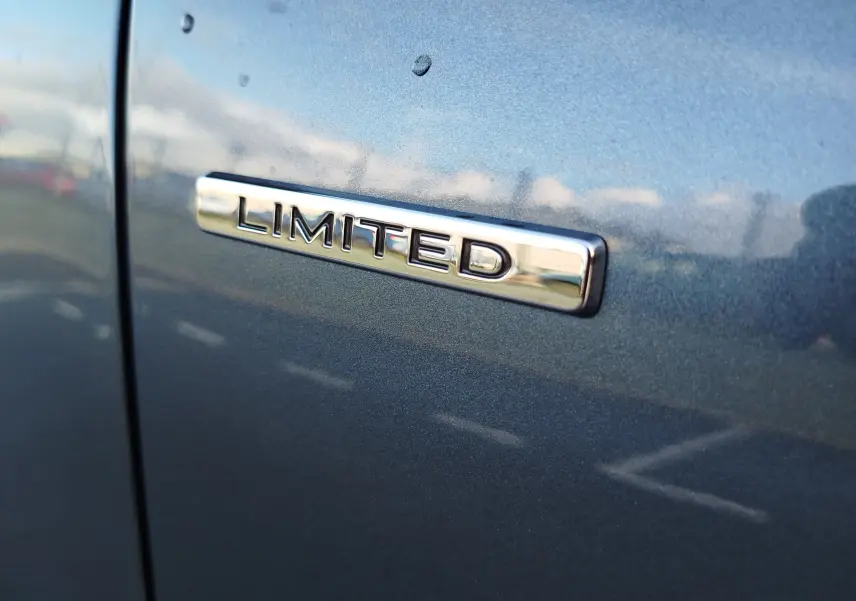Gros plan sur l’inscription "Limited" en chrome sur la carrosserie gris titanium d’un Renault Kadjar 2021.