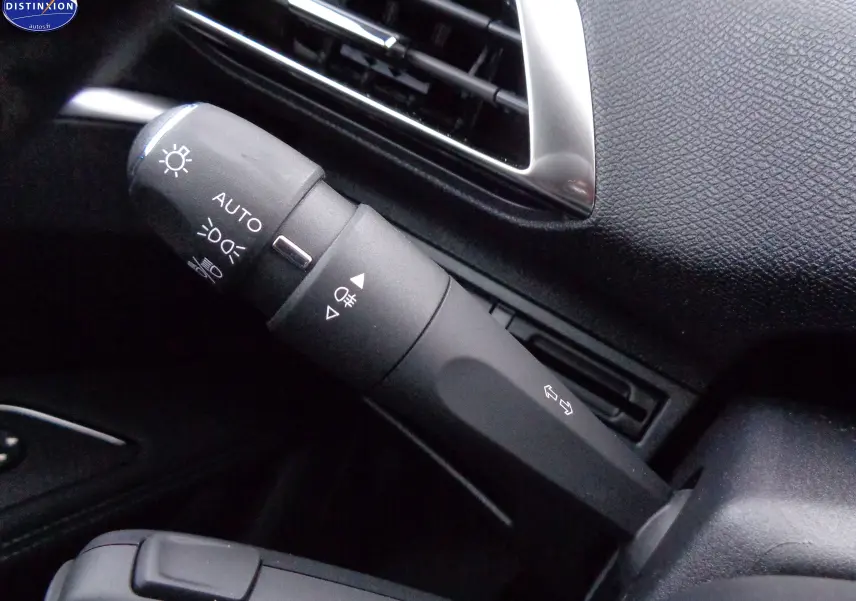 Gros plan sur la commande des feux et clignotants dans l'habitacle noir du Peugeot 3008 2023.
