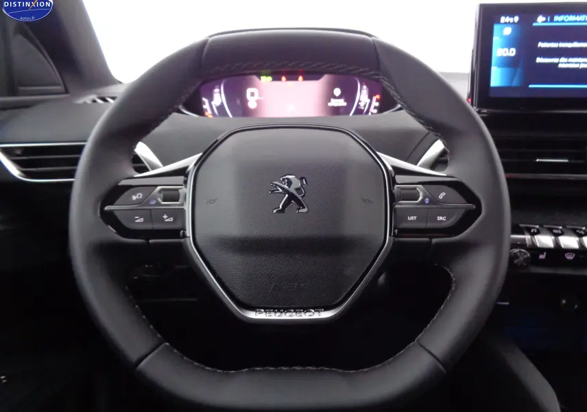 Vue rapprochée du volant cuir noir du Peugeot 3008 2023 avec commandes intégrées et tableau de bord numérique.