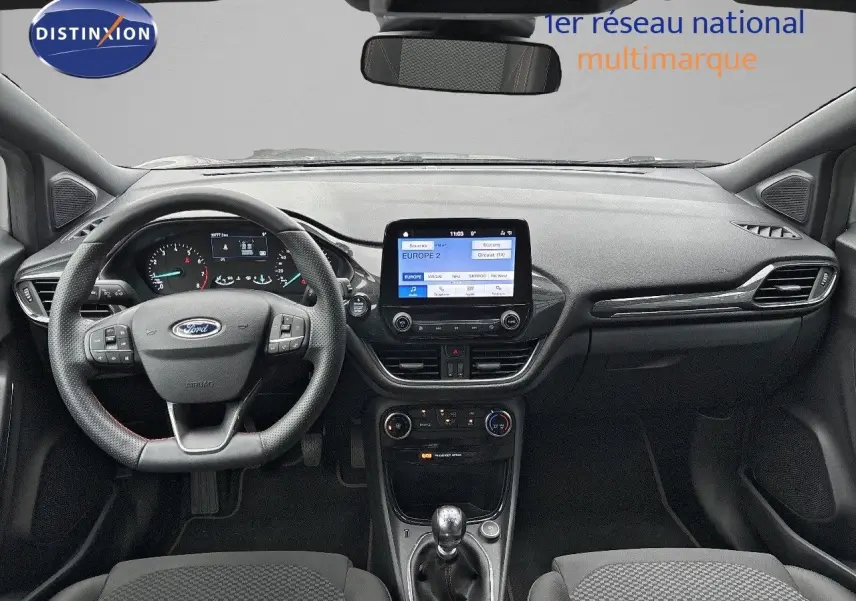 Vue intérieure frontale du tableau de bord gris et noir du Ford Puma 2022 avec écran tactile et volant multifonction.
