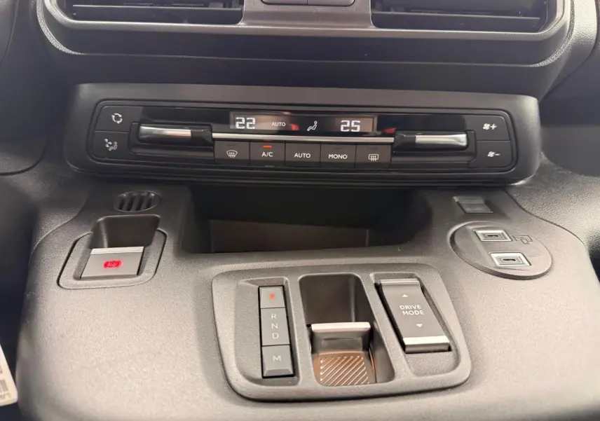 Vue rapprochée du tableau de bord gris du Citroën Berlingo 2025, montrant la climatisation digitale et la commande de boîte automatique.