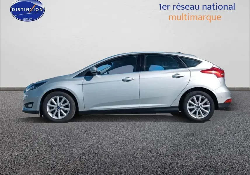 Profil latéral droit d'une Ford Focus gris clair 2017 avec jantes alu et becquet arrière visible.