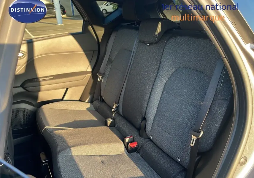 Vue intérieure arrière droite du Renault Captur E-Tech gris cassiopée, montrant les sièges arrière en tissu gris.